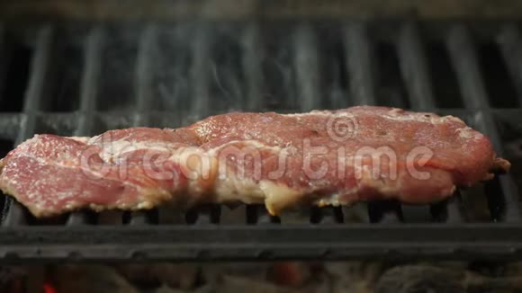 Semislotte牛排躺在烤架上在烤架的背景烟雾中观看侧面特写的视频视频的预览图