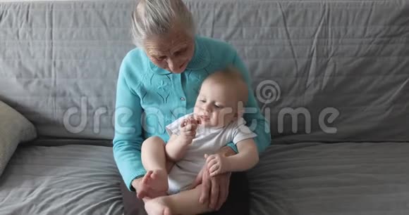 一位白发苍苍皱纹深的老奶奶怀里抱着一个孙子视频的预览图