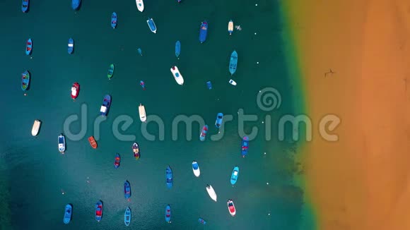 在西班牙卡纳里斯岛的特内里费海滩上俯瞰金色的沙滩和五颜六色的小船视频的预览图