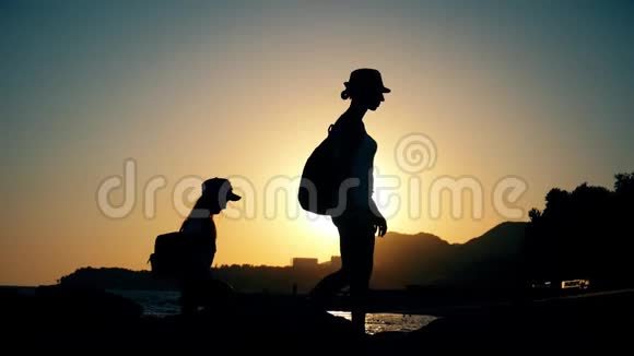 日落时徒步旅行的母子游客剪影妈妈和女儿在暑假背背包视频的预览图