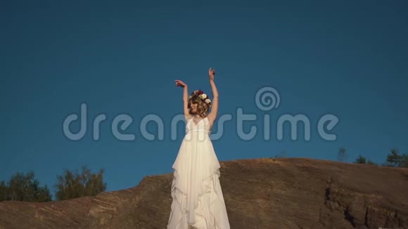 这位身穿白色长裙头戴花圈的美女正享受着山里的宁静时光视频的预览图