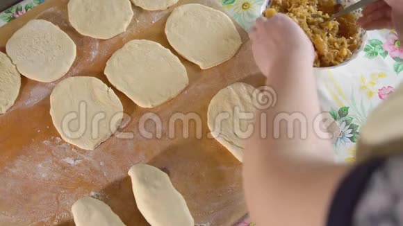 在木板上准备馅料馅饼的女人视频的预览图