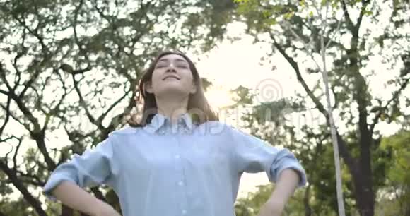 一幅年轻迷人的亚洲女人在一个夏天的公园里快乐的肖像视频的预览图