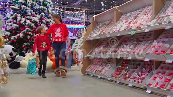 圣诞节期间母亲和儿子在购物中心散步时拥抱的幸福家庭肖像视频的预览图