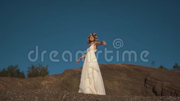 这位穿着波霍式白色长裙头上戴着花圈的漂亮姑娘正在花时间视频的预览图