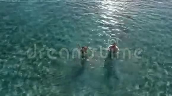 年轻的女孩和男人在海里游泳视频的预览图