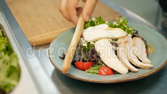 厨师在餐厅厨房里把烤盘放在沙拉上一步一步地做沙拉视频的预览图