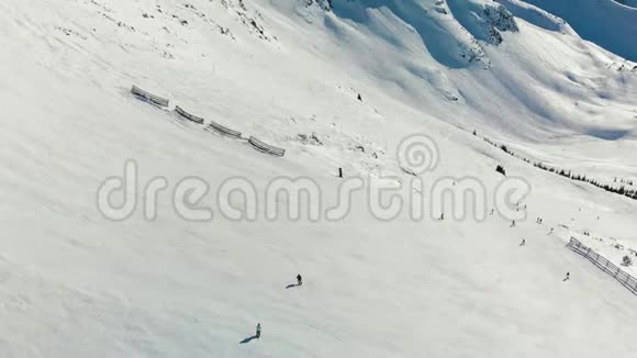 在阳光明媚的一天布莱克科姆山和滑雪者的空中镜头视频的预览图
