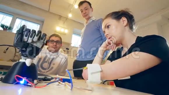 残疾妇女正在移动她截肢的手机器人的手在做一些动作工程师们正在控制视频的预览图