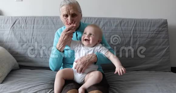 一个老奶奶带着深深的海象坐在沙发上怀里抱着一个小孙子视频的预览图