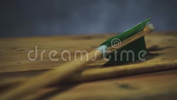 旋转圆木桌上的老绿色木箭美丽的黑暗背景视频的预览图