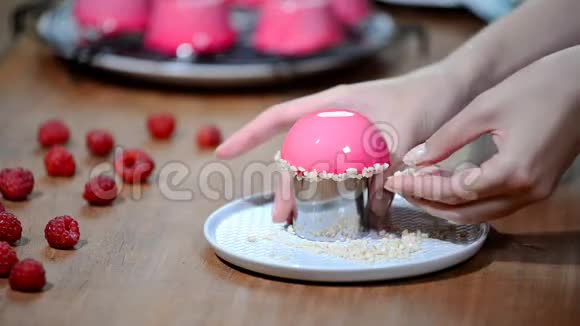 法式覆盆子慕斯蛋糕配粉红色镜面釉用坚果装饰蛋糕视频的预览图