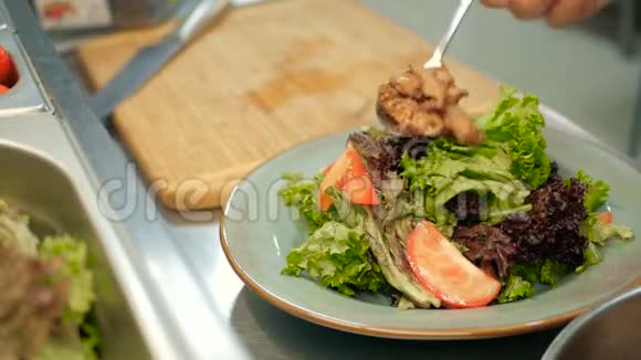 厨师在餐厅的厨房里把炸肝片放在沙拉上一步一步地做沙拉视频的预览图