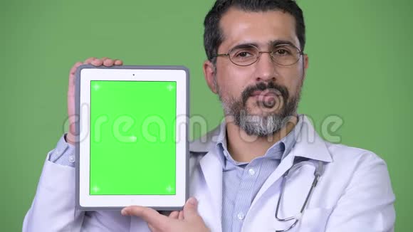 英俊的波斯胡子男医生展示数码平板电脑视频的预览图