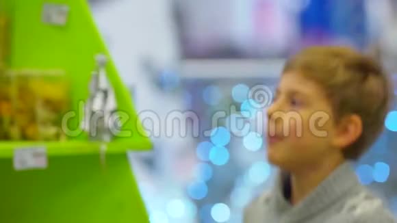 快乐的孩子在圣诞节期间在购物中心向他的母亲展示雪球视频的预览图