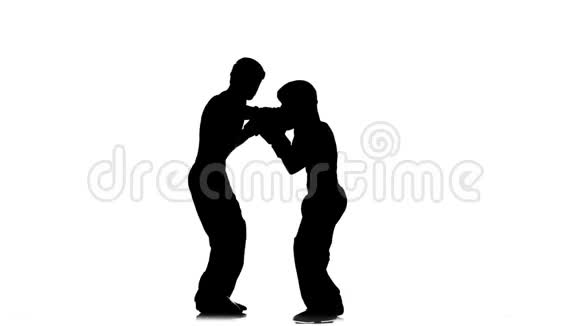 戴着头盔和拳击手套的男人在拳击场上打剪影白色背景视频的预览图