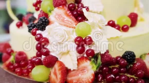 以红色醋栗浆果葡萄草莓黑莓覆盆子和奶油为装饰的蛋糕视频的预览图