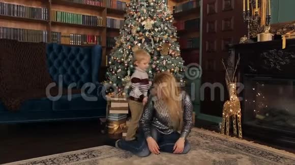 母亲和儿子在圣诞树附近玩得很开心视频的预览图