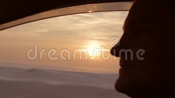 年轻人在夕阳下开车戴着太阳镜特写镜头视频的预览图