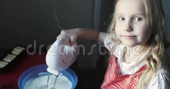 迷人的女孩用搅拌器抽打蛋糕奶油视频的预览图