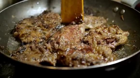 在煎锅中放入美味的牛肉猪肉或肝烤肉烹饪的概念视频的预览图