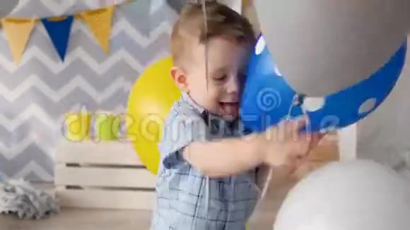 快乐的孩子正在玩蓝色和灰色的气球为他的生日礼物视频的预览图