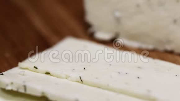 粗糙的白色小屋奶酪在砧板上切割草药视频的预览图