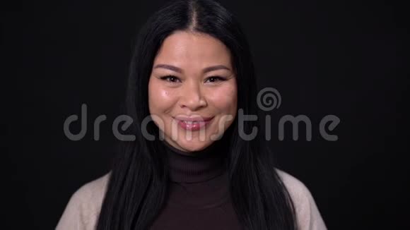 在黑暗的背景下微笑着的亚洲女商人视频的预览图