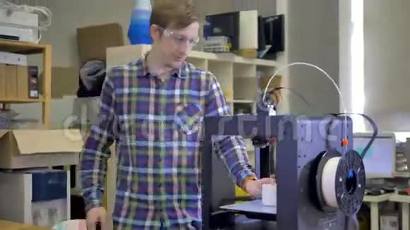 这个人正在看3D打印机上打印的细节4K视频的预览图