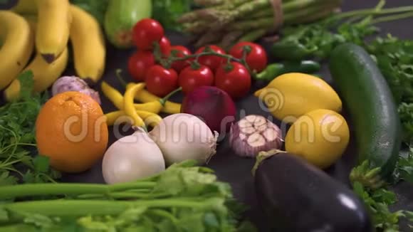 黑桌子上摆着一大套有机的五颜六色的新鲜蔬菜视频的预览图
