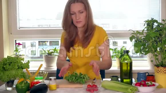 坐在厨房的餐桌旁吃小番茄蔬菜的孕妇视频的预览图