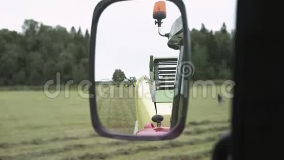 从农场草地上驾驶的农用拖拉机小屋的后视镜视频的预览图