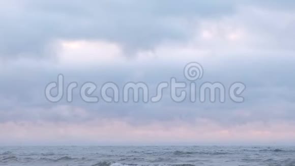 薄雾和雾气笼罩着海面美丽的海景粉红色的日落和蓝色的云彩视频的预览图