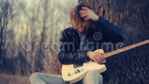 日落时弹吉他的年轻人视频的预览图
