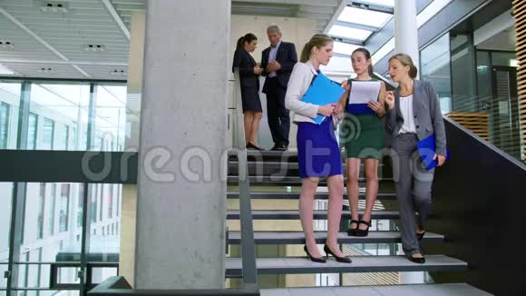 女商人站在楼梯上讨论文件视频的预览图