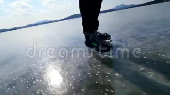 穿着冰鞋的不知名运动员的腿冻湖上的人视频的预览图
