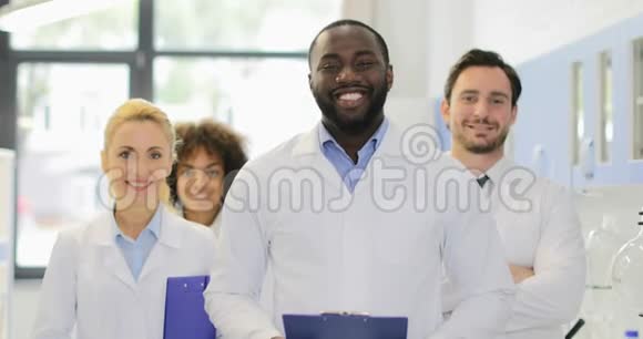 现代实验室快乐微笑的非裔美国科学家和研究团队视频的预览图