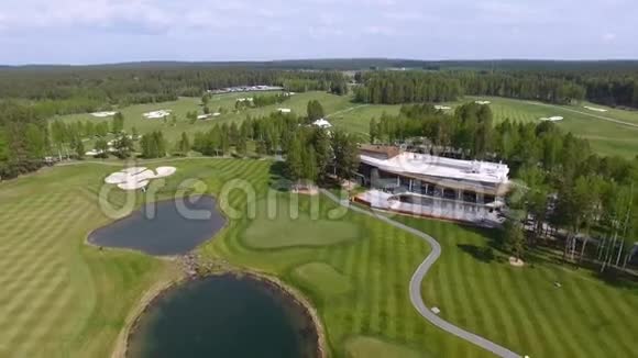 高尔夫球场上的鸟瞰景观有华丽的绿色和池塘视频的预览图