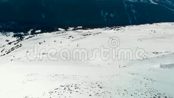 在阳光明媚的一天布莱克科姆山和滑雪者的空中镜头视频的预览图