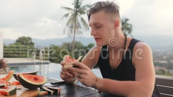 吃素晚餐时享用美味西瓜的快乐男人视频的预览图