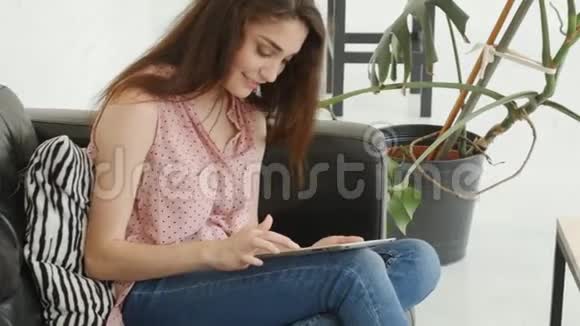 个人小玩意的概念家里拿着平板电脑的年轻女子视频的预览图