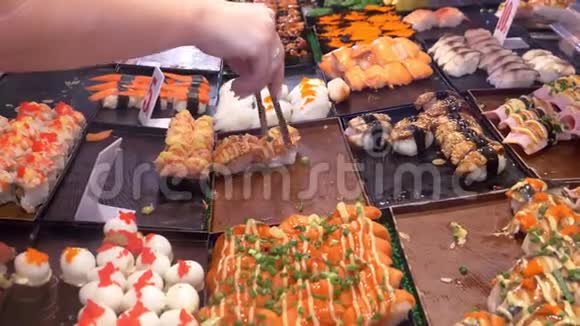 亚洲美食美食理念接近手拿钳子在街上的夜市上选择寿司视频的预览图