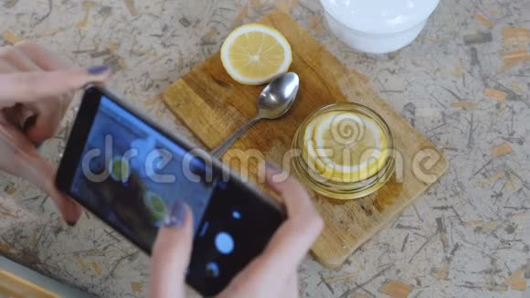 特写女人手与电话制作照片片柠檬在罐子里视频的预览图