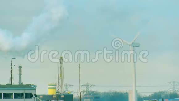 旋转风力发电机和烟雾超过工业区清洁和肮脏能源生产概念视频的预览图