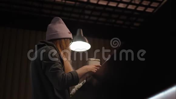 一位戴着时髦眼镜和帽子的时髦女性在咖啡馆里选择茶视频的预览图