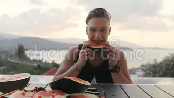 欢乐的人在夏日露台上吃西瓜有海景视频的预览图