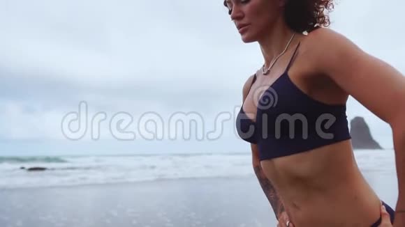 年轻美丽的女人在海滩上做运动日出早操健康的生活方式锻炼做仰卧起坐视频的预览图