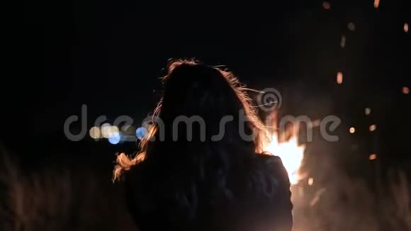 女孩正在炉火旁取暖大火灾背景下的人视频的预览图