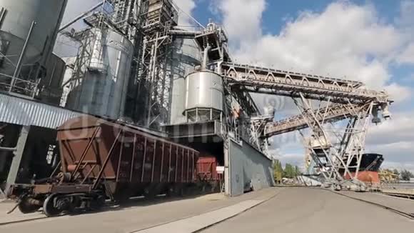 以农作物为货物运输的货运列车在靠近海上的大谷物码头上行驶卸粮视频的预览图