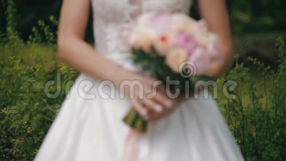 新娘捧着一束玫瑰和牡丹的婚礼花束婚礼当天的新娘花束不同花束视频的预览图